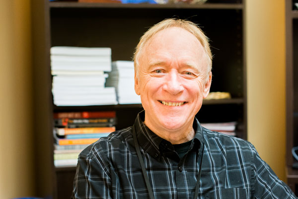 A man with short blond hair and a plaid button-up shirt